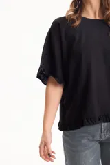 Blusa de lino color crudo, de manga corta con detalles de volados en las mangas y en el ruedo.