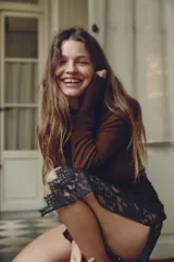 Camiseta negra traslúcida de manga larga con cuello alto y terminaciones onduladas. Confeccionada en hilatura con lyocell y lana.