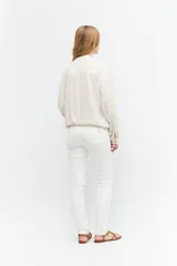 Chaqueta bomber color beige melange, de lino, con cuello mao, cierre frontal con botones a presión, dos bolsillos con solapa en el pecho y puños y cintura elastizados.