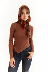 Top de manga larga color blanco, confeccionado en tejido de punto acanalado con diseño irregular y aberturas para los pulgares en los puños.