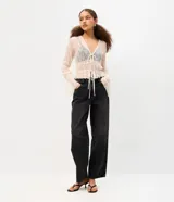 Pantalón baggy de jean color gris oscuro, de tiro medio y corte holgado, con bolsillos frontales y traseros.