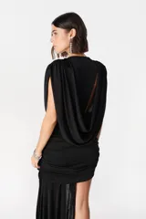 Vestido corto de diseño asimétrico en color verde oliva, con escote profundo en V, drapeado frontal y una caída lateral larga que llega hasta el suelo. Sin mangas y con ajuste entallado en la falda.