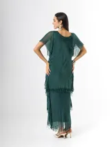 Vestido largo de seda italiana color verde oscuro, con capas escalonadas con flecos, escote en V con detalle de paillettes y mangas cortas fluidas.