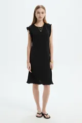 Vestido midi negro de poliéster, de corte recto y escote redondo, con volados sutiles en los hombros y el ruedo.