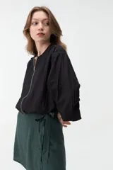Campera negra corta con cierre frontal y mangas anchas.