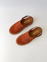 Zueco de cuero color ladrillo con correa trasera ajustable color marrón oscuro y suela track color marrón claro.