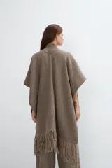 Ruana marrón con flecos y bolsillos. Terminaciones envivadas.