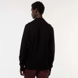 Remera de manga larga negra con cuello polo y tapeta de dos botones. Presenta un tejido de punto de fantasía con textura de pequeños puntos.