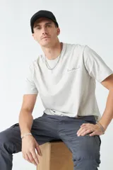 Remera de hombre color gris claro con cuello redondo y estampado con texto en el pecho.