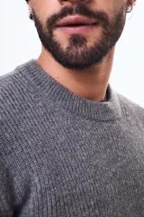 Buzo de tejido de punto con cuello redondo, de corte clásico y manga larga, con puños y ruedo acanalados.