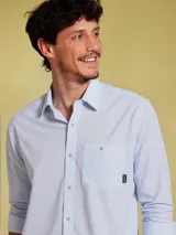 Camisa celeste a rayas verticales finas, de manga larga y corte clásico.