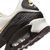 Championes Nike Air Max 90 con diseño clásico, combinando paneles de cuero blanco, beige y detalles en negro con textura de reptil. Cuenta con la icónica unidad de aire visible en el talón y suela de goma resistente.