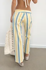 Jeans rectos de tiro bajo, confeccionados en denim con diseño de rayas verticales en tonos amarillo, celeste y rosado, estilo cropped, con cierre frontal de cremallera y botón metálico, presillas para cinto y clásico diseño de cinco bolsillos.