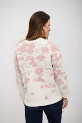 Buzo de tejido de punto con diseño estampado floral en tonos rosa y gris sobre base color crudo. Presenta cuello redondo y mangas largas con puños ajustados.