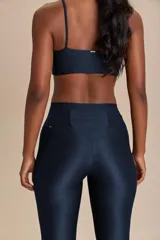Calza deportiva de tiro alto con diseño de alta compresión y textura acanalada con leve brillo. Cuenta con un bolsillo trasero en la cintura y tecnología de ajuste adaptable.