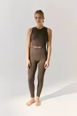 Top deportivo sin mangas color marrón oscuro, tejido en morley sin costuras. Presenta escote redondo y logo tejido a contratono en la espalda.