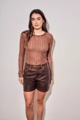 Remera de encaje negro ajustada al cuerpo, de manga larga y diseño transparente.