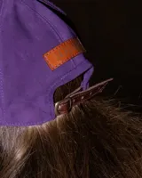 Gorra de cuero sintético color violeta, con diseño estructurado y visera curva.