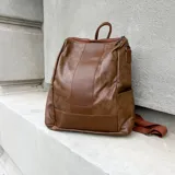 Mochila negra de eco cuero con cierre superior y correas ajustables.