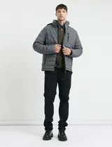 Campera puffer gris oscuro con capucha desmontable, cierre frontal con cremallera y botones a presión, bolsillos laterales con cierre y detalles en color naranja.