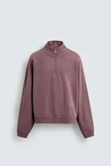 Sudadera de corte boxy fit con cuello subido y cierre frontal de cremallera. Presenta mangas largas, acabado efecto lavado y puños y ruedo en rib.