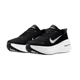 Championes Nike modelo Vomero Plus para running, color negro con entresuela blanca gruesa de tecnología ZoomX y el clásico swoosh de Nike en blanco en el lateral.