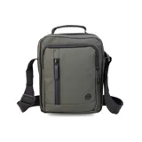 Bandolera color verde militar de tela impermeable, con correa regulable y asa superior. Tiene dos bolsillos frontales con cierre y un bolsillo trasero con cierre.