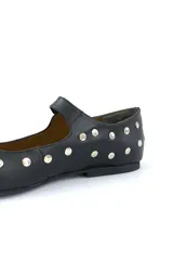 Zapato tipo Mary Jane de cuero negro con tachas plateadas, punta redondeada y tira con hebilla.