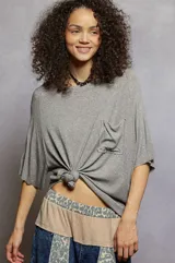 Remera de manga corta con diseño holgado, cuello redondo y bolsillo frontal aplicado en el pecho.