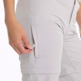 Pantalón de trekking desmontable color gris claro, con cintura elástica, cinturón interno ajustable, bolsillos con cierre y elástico interior en los tobillos.