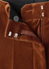 Pantalón de corte recto y tiro medio confeccionado en tejido de terciopelo. Cuenta con bolsillos laterales, bolsillos de ribete en la parte posterior, trabillas para cinturón y cierre oculto con botón, gancho y cremallera.