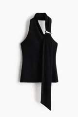 Top negro de punto suave, con escote asimétrico estilo halter y una tira ancha tipo fular sujeta con un detalle metálico decorativo. Presenta frunces laterales que generan un efecto drapeado sutil.