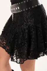 Pollera corta de encaje negro con diseño de vuelos y movimiento ligero, ideal para un look romántico y elegante.