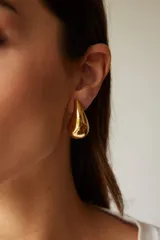 Aros dorados con diseño tridimensional en forma de gota, con acabado brillante.