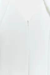 Vestido midi de color blanco, con escote en V y mangas cortas abullonadas.