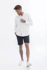 Camisa blanca de manga larga con cuello clásico y corte recto.