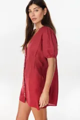 Vestido corto negro de lino italiano, con escote en V, mangas cortas abullonadas y cierre frontal de botones con cintura entallada y tablas.