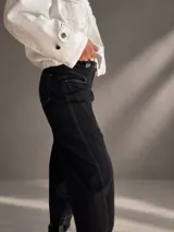 Jeans barrel de tiro alto, confeccionados en denim azul muy oscuro casi negro, con pespuntes contrastantes, diseño de pierna amplia y redondeada, y bolsillos delanteros.