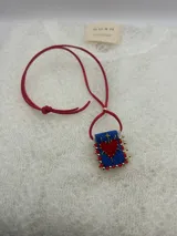 Collar con dije rectangular bordado con un corazón rojo y detalles de mostacillas de colores.