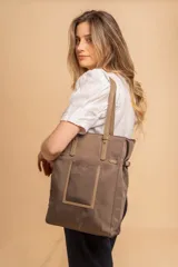 Cartera tipo tote de gran capacidad, confeccionada en nylon color gris con detalles en símil cuero al tono. Cuenta con doble asa de hombro, bolsillo frontal externo y cierre superior.