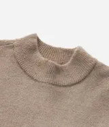 Sweater de punto color beige, con cuello alto y mangas largas acampanadas.