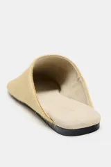Zapato tipo mule de mujer confeccionado en piel con textura de pelo en color beige. Presenta un diseño de punta redonda y suela plana en contraste.