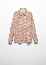 Camisa de corte recto y tejido fluido, con cuello camisero clásico, cierre frontal de botones y mangas largas con puños abotonados.