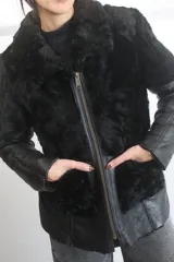 Gamulán reversible de cuero genuino color negro, con interior de piel sintética negra, cierre frontal metálico y mangas de cuero.