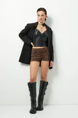 Top negro de símil cuero con escote en V, sin mangas, pinzas y corte en la cintura. Cierre metálico en la espalda.