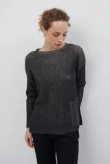 Buzo de tejido de punto acanalado en color negro con sutiles líneas verticales en tono contrastante. Presenta cuello redondo, mangas largas y un bolsillo tipo parche en el frente.