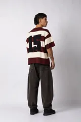 Remera de tejido de punto con diseño de rayas horizontales anchas en color bordó y crema, de corte oversize y cuello redondo.