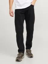 Jean negro de tiro alto, corte tapered, cinco bolsillos y cierre con botón.