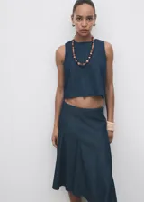 Top sin mangas de efecto denim con cuello redondo y diseño ajustado en la cintura con ligero vuelo en el bajo. Cuenta con cierre de botón en la parte posterior del cuello.