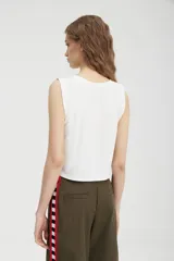 Musculosa blanca corta con estampado de la palabra "Dreamland" en color rojo.